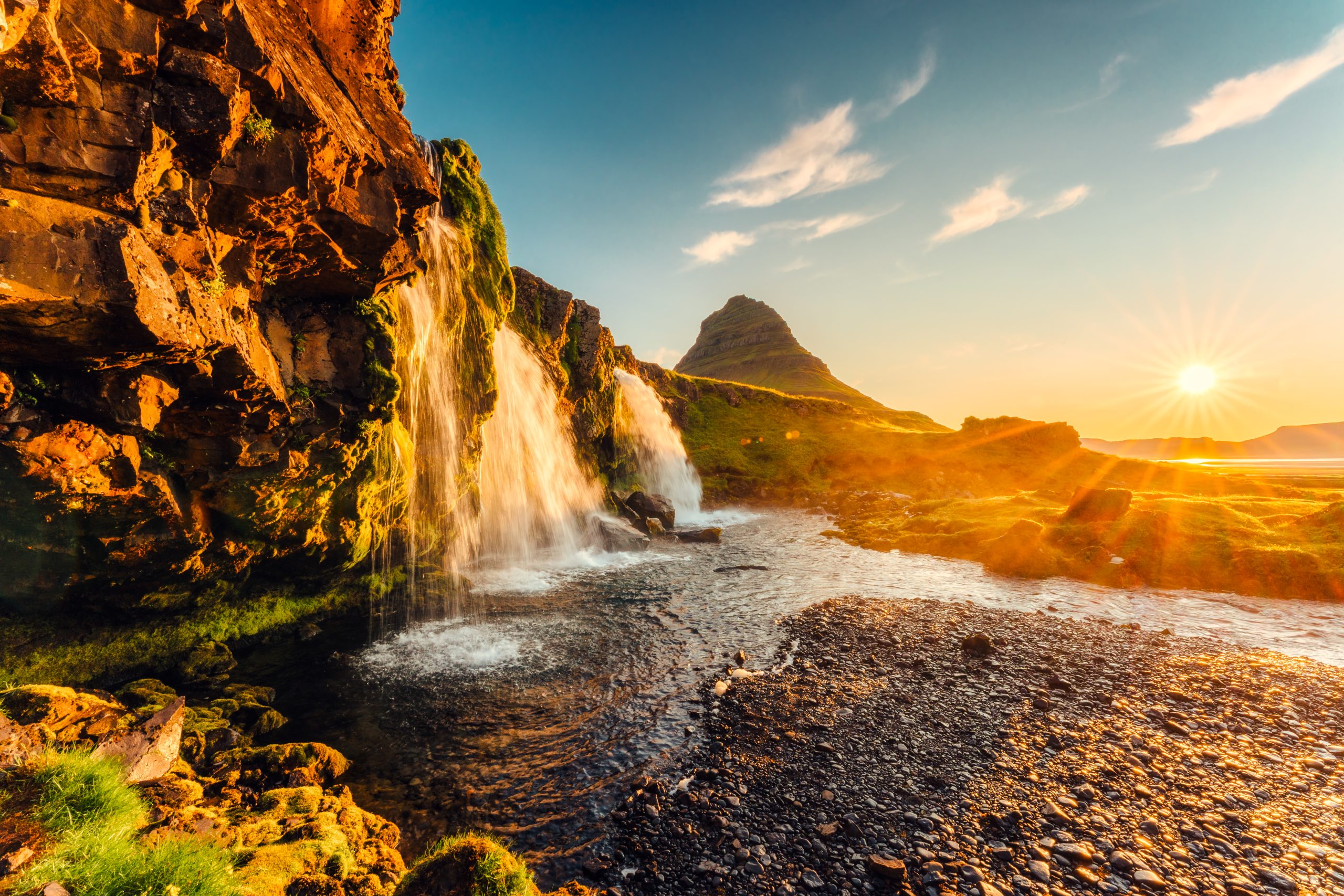 La cascata Kirkjufellsfoss con il monte Kirkjufell sullo sfondo nella luce del tramonto
