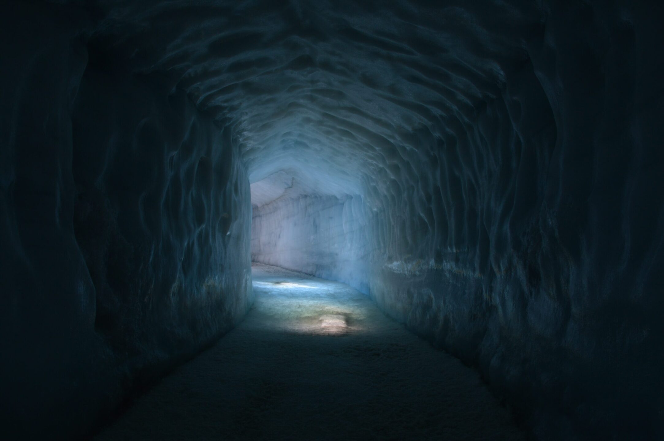 Corridoio nel ghiaccio che conduce verso un’apertura illuminata